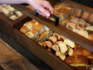 a person is reaching for a tray of bread at ONE@Tokyo by insomnia in Tokyo