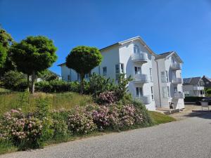 a white building with flowers in front of it at Villa Monika Backbord 2 in Sassnitz +1 photo