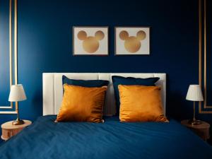 a blue bedroom with a bed with orange pillows at Disneyland Magic Home in Couilly-Pont-aux-Dames