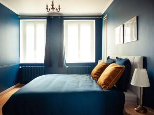a blue bedroom with a bed and two windows at Disneyland Magic Home in Couilly-Pont-aux-Dames +19 photos