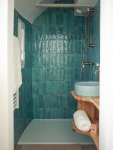 a green tiled bathroom with a tub and a sink at Disneyland Magic Home in Couilly-Pont-aux-Dames