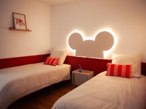 two beds in a room with an elephant light on the wall at Disneyland Magic Home in Couilly-Pont-aux-Dames