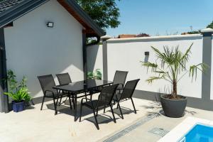 a black dining table and chairs on a patio at Villa Azure Sea in Bijeljina