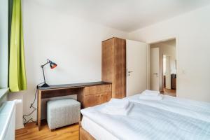 ein Schlafzimmer mit einem Bett und einem Schreibtisch mit Lampe in der Unterkunft Bodeapartment 4 in Elend