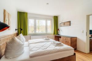 ein Schlafzimmer mit einem Bett und einem Fenster mit grünen Vorhängen in der Unterkunft Bodeapartment 4 in Elend