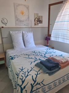 a bedroom with a bed with a blue and white blanket at Villetta La Ginestra in Stintino +38 photos