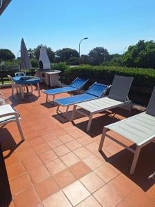 a group of chairs and tables on a patio at Villetta La Ginestra in Stintino
