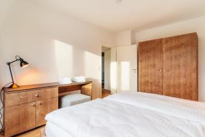 a bedroom with a white bed and a desk at Bodeapartment 8 in Elend