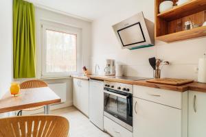 a kitchen with white cabinets and a table and a window at Bodeapartment 8 in Elend