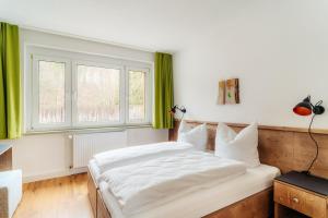 a bedroom with a large white bed and a window at Bodeapartment 3 in Elend