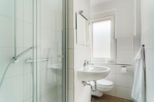 a white bathroom with a sink and a toilet at Bodeapartment 3 in Elend