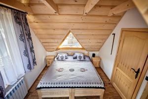 a bedroom with a bed in a attic at Domki Pod Góralskim Niebem in Zakopane