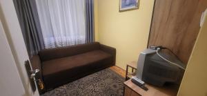 a living room with a couch and a tv at Pokoje u Irenki in Augustów