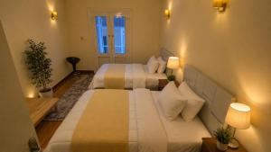 two beds in a small room with two lamps at Stay Ra3 Suites in Cairo