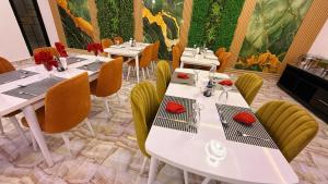 a dining room with white tables and yellow chairs at Hôtel Mandela Nouakchott in Nouakchott