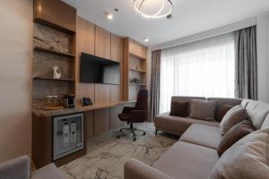 a living room with a couch and a desk at Hotel Decebal in Bacău