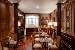 a dining room with tables and chairs and a window at The Britannia Hotel in Rome +46 photos