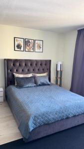 a bedroom with a large bed with a blue comforter at TEATRA Apartamenti in Liepāja