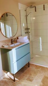 a bathroom with a sink and a mirror and a shower at Les Prés du Manoir in Le Manoir