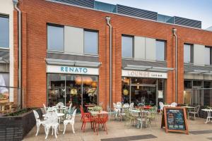 a restaurant with tables and chairs in front of a building at 1 Bed Apartment Sleeps 2 -Free Parking -WiFi & Tv in Sutton Coldfield