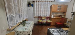a small room with a table and a kitchen at Pokoje u Irenki in Augustów