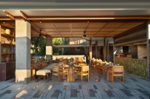 a restaurant with wooden tables and chairs on a patio at Alaya Suites Ubud in Ubud