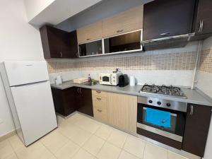 a kitchen with a stove and a white refrigerator at Dream City Center in Piteşti