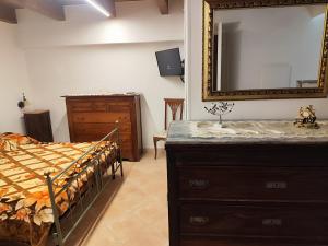 a bedroom with a bed and a mirror and a dresser at La Scienza Nuova in Vatolla +3 photos