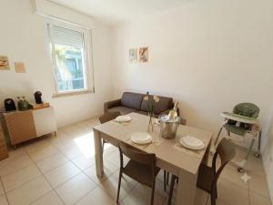 a living room with a table and a couch at Free Parking a 100 mt dal mare-Wave HuoSe in Pesaro