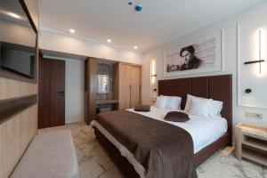 a bedroom with a large bed and a flat screen tv at Hotel Decebal in Bacău +66 photos