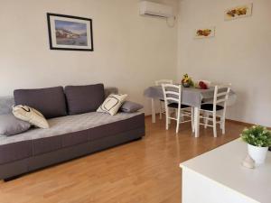 a living room with a couch and a table at Apartman Perka in Valbandon +2 photos