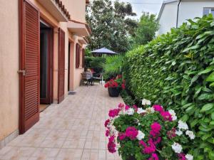 a courtyard with flowers and a patio with an umbrella at Apartman Perka in Valbandon