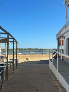 a beach with chairs and a building on the sand at Marenga in El Rompido