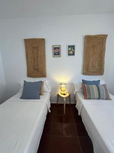 two beds in a room with a table between them at Marenga in El Rompido