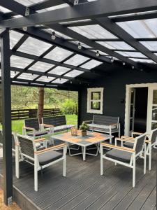 a pergola with a table and chairs on a deck at Mystica Forest in Braziūkai