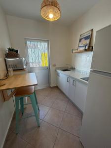 a small kitchen with a table and a refrigerator at Marenga in El Rompido