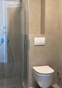 ein Badezimmer mit Toilette und Glasdusche in der Unterkunft Hotel Keto in Podgorica + 33 Fotos