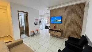 a living room with a tv on a wall at CRCN - Evian Thermas Residence in Caldas Novas