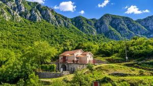 a house on a hill with mountains in the background at The Mountain's Embrace Villa in Gluhi Do