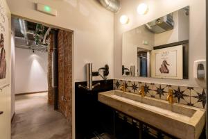 a bathroom with a sink and a mirror at Black Swan Hostel Granada in Granada +69 photos