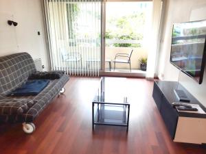 a living room with a couch and a glass table at A 200 m du centre historique, profitez d'un T2 spacieux avec balcon et parking privé in Quimper