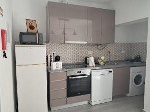 a kitchen with a white refrigerator and a dishwasher at Refúgio Viçoso in Vila Viçosa
