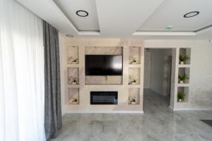 a living room with a television and a fireplace at Villa Azure Sea in Bijeljina +21 photos