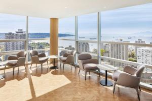 a waiting room with chairs and tables and windows at Sheraton Vancouver Wall Centre in Vancouver