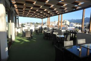 a restaurant with tables and chairs on a balcony at Grand Center Boutique Hotel in Kyrenia