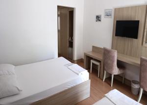 a hotel room with a bed and a desk with a television at Grand Center Boutique Hotel in Kyrenia