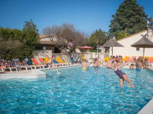 a group of people playing in a swimming pool at Camping Pegomas in Saint-Rémy-de-Provence