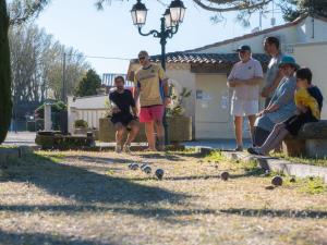 a group of people standing in a yard with balls in the grass at Camping Pegomas in Saint-Rémy-de-Provence