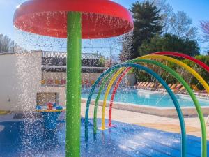 a swimming pool with a water park with a fountain at Camping Pegomas in Saint-Rémy-de-Provence