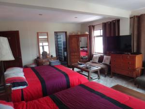 Habitación de hotel con 2 camas y TV en Rendezvous Hostal, en La Paz